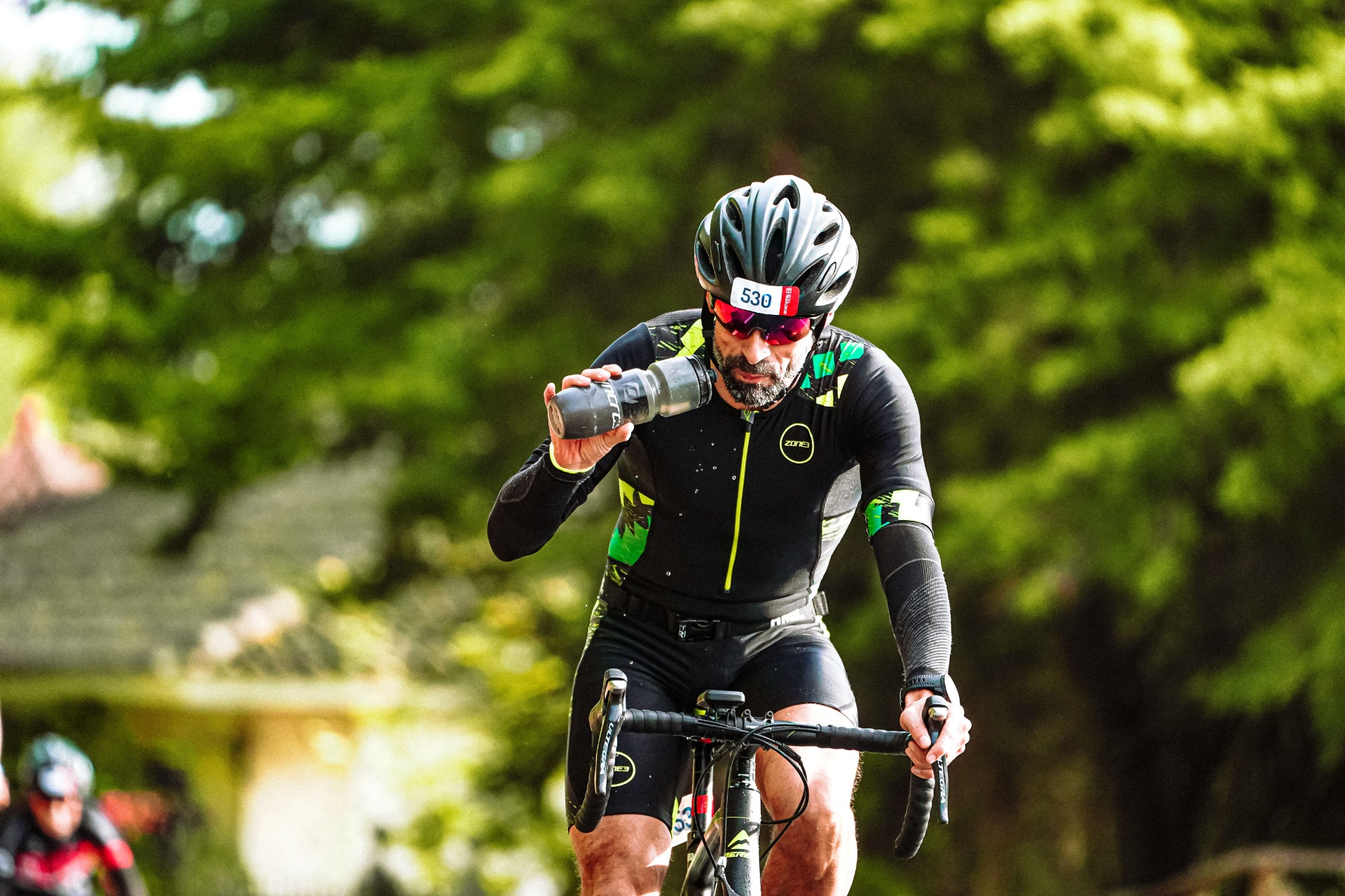 Radrennfahrer trinkt aus seiner Trinkflasche beim Event